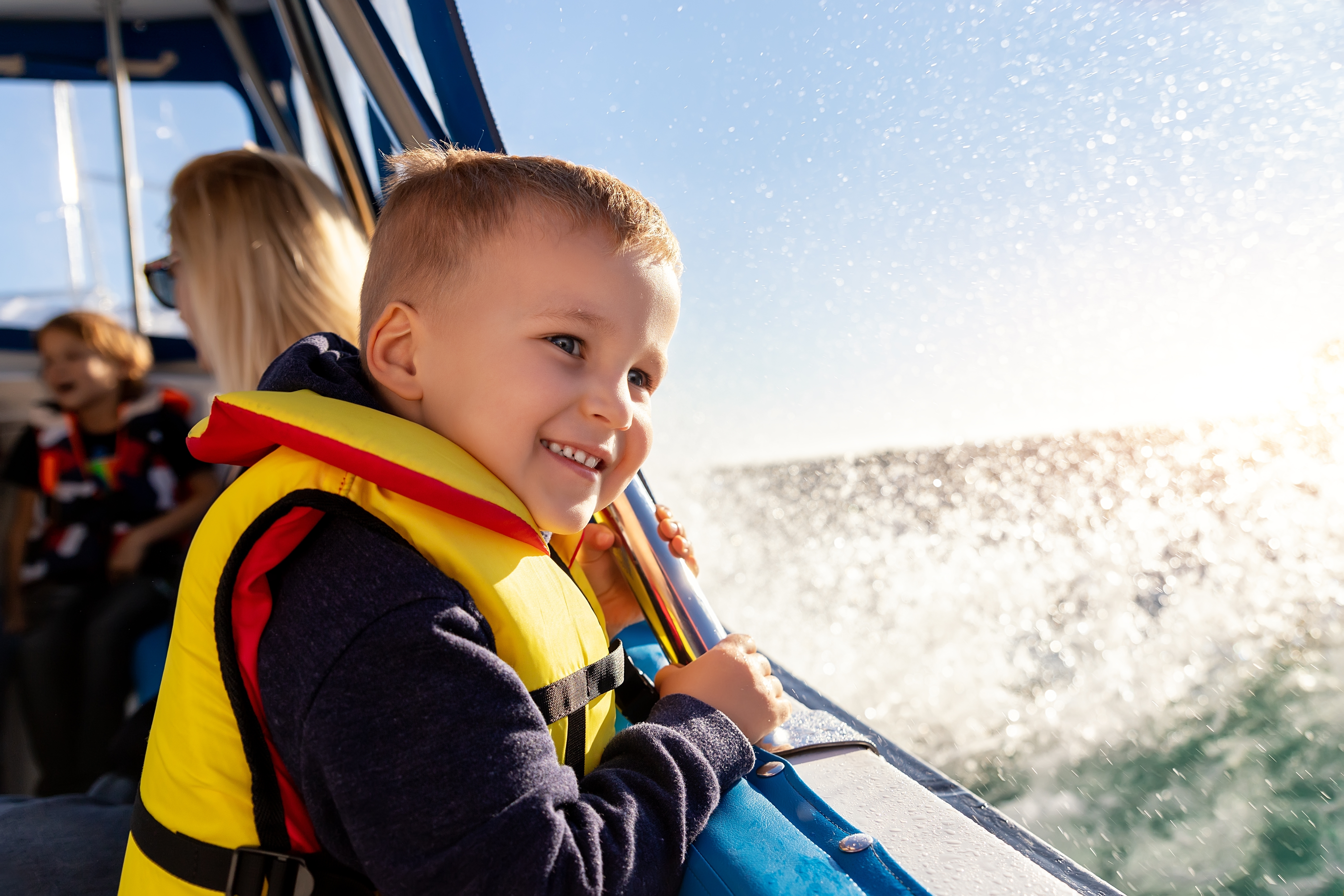 Kid on a lifejacket on a boat. 