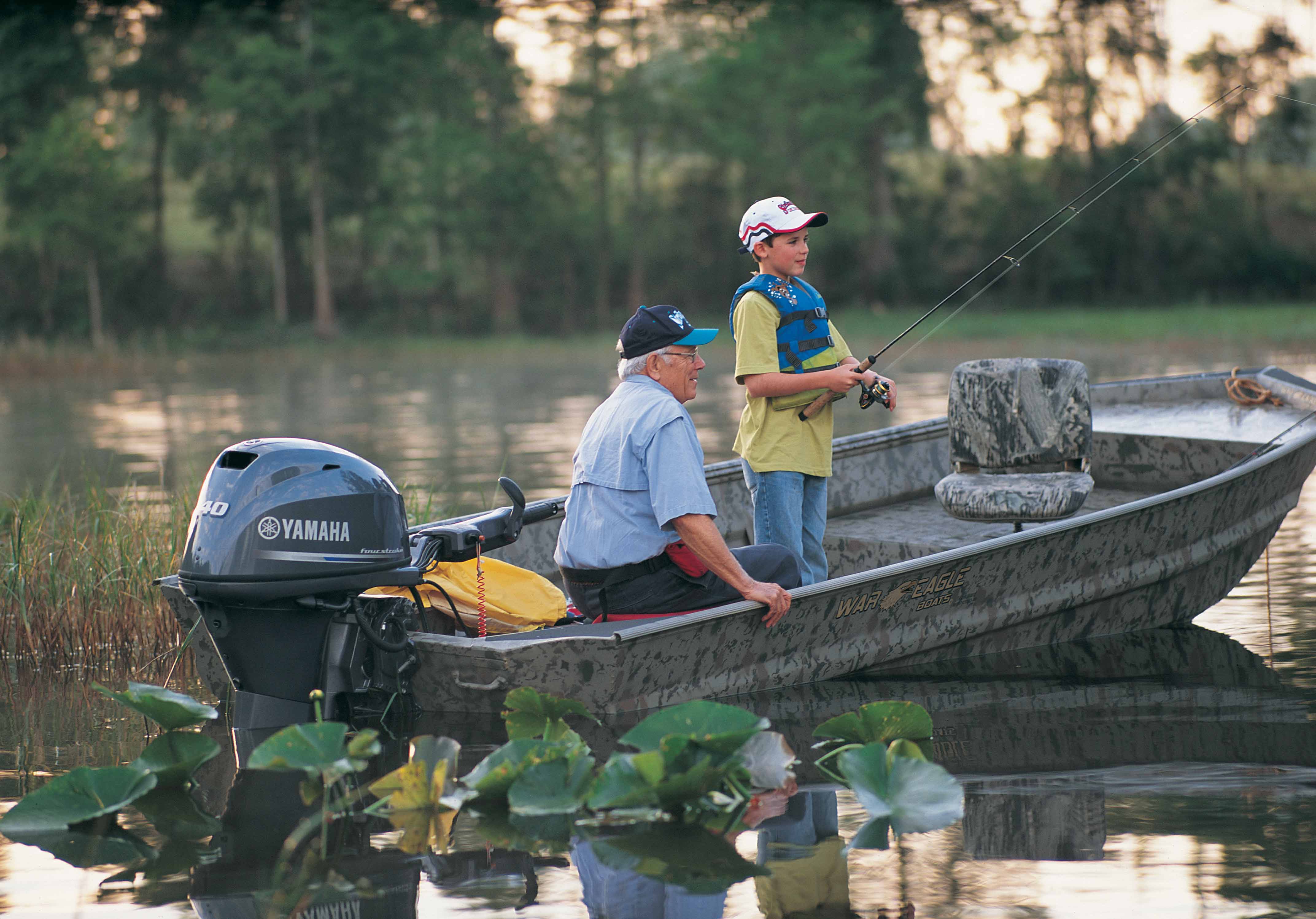 Grandfather and grandson out fishing on a War Eagle boat.